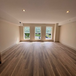 a living room with wood flooring and windows