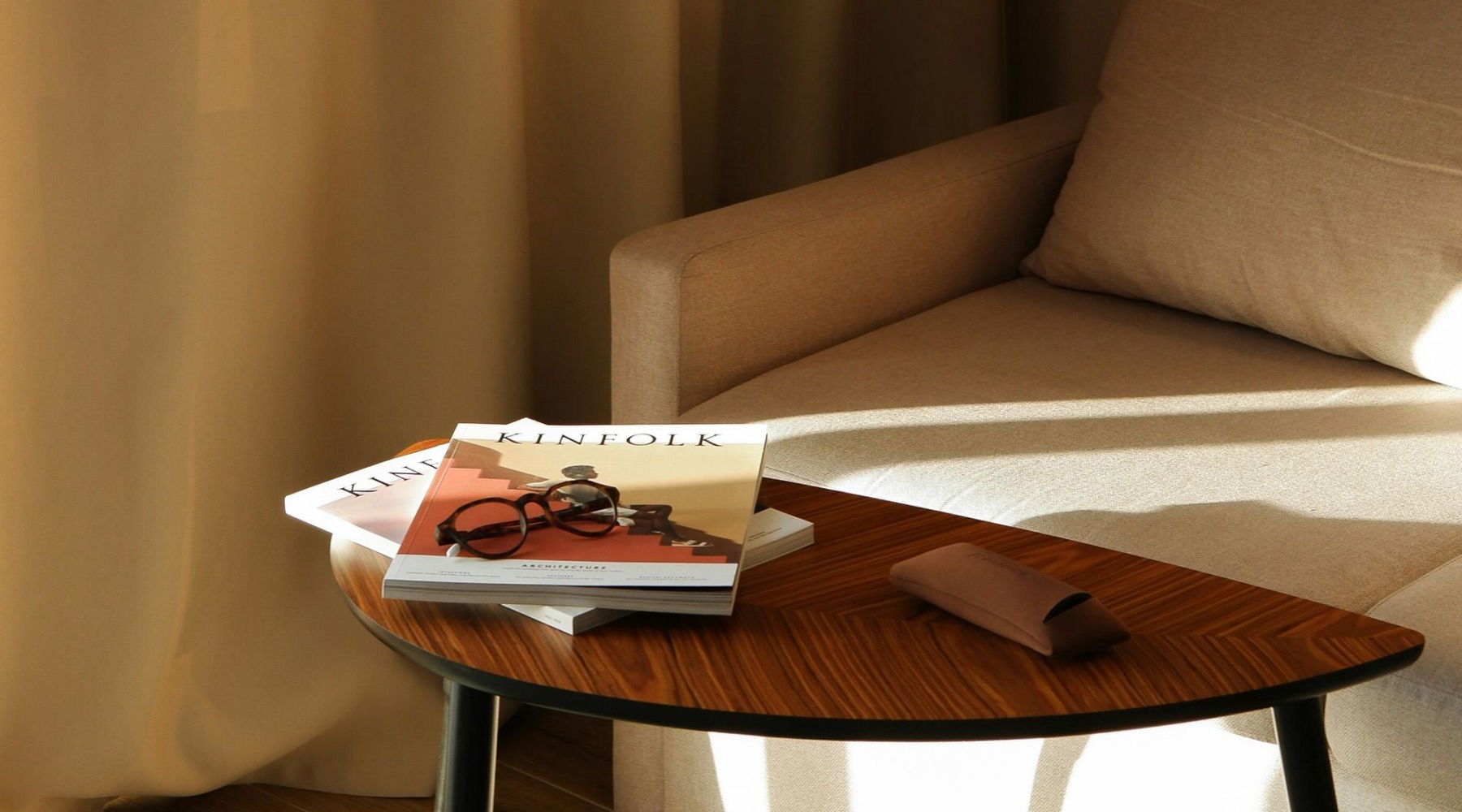 a coffee table with books on it next to a couch